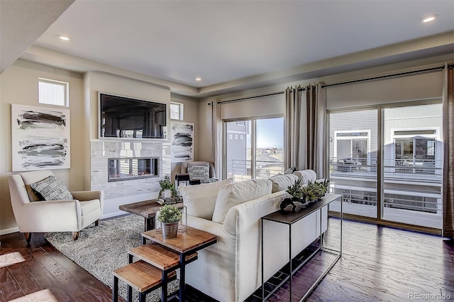 living room with hardwood / wood-style flooring and a tile fireplace