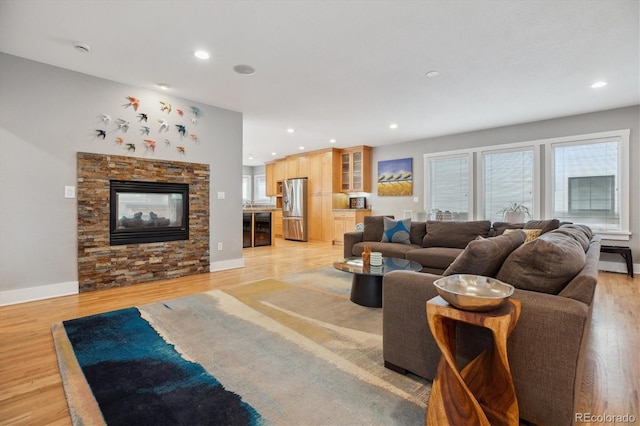 1526 S Gaylord St, Denver, CO 80210 - living area featuring wine cooler, light wood-style flooring, recessed lighting, a stone fireplace, and baseboards