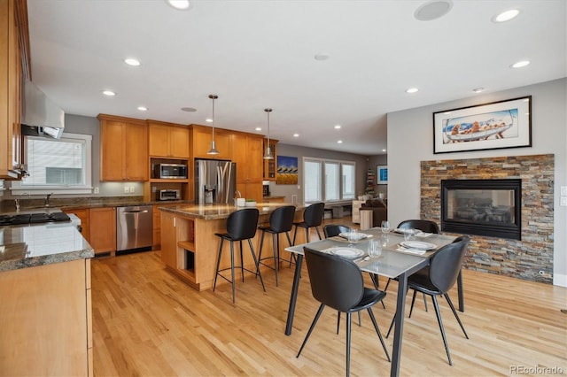 1526 S Gaylord St, Denver, CO 80210 - dining space with light wood finished floors, a stone fireplace, and recessed lighting