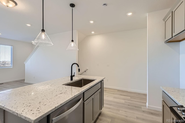 kitchen with sink, stainless steel dishwasher, a kitchen island with sink, and light stone countertops