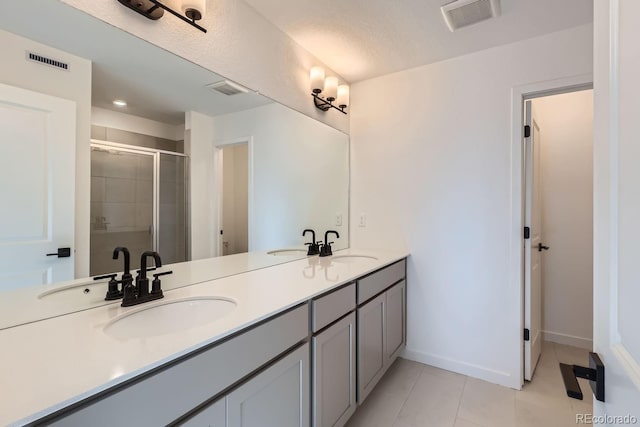 bathroom featuring tile patterned floors, vanity, and an enclosed shower