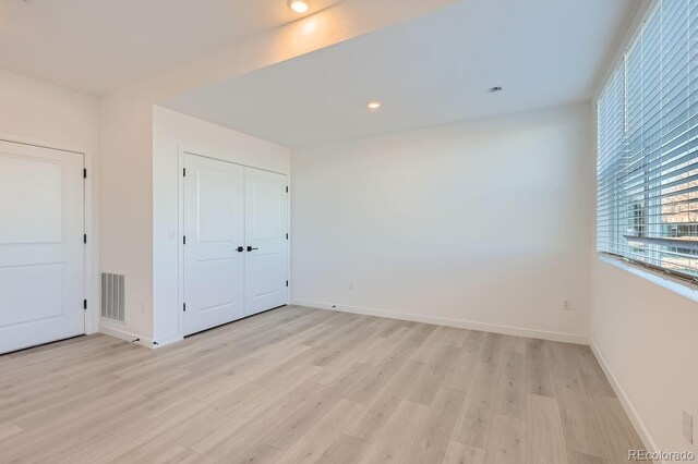 unfurnished bedroom with light hardwood / wood-style floors and a closet