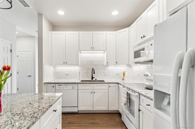 kitchen featuring tasteful backsplash, white appliances, dark hardwood / wood-style flooring, and white cabinets