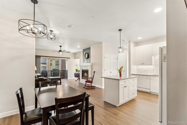 dining space with light hardwood / wood-style flooring and ceiling fan