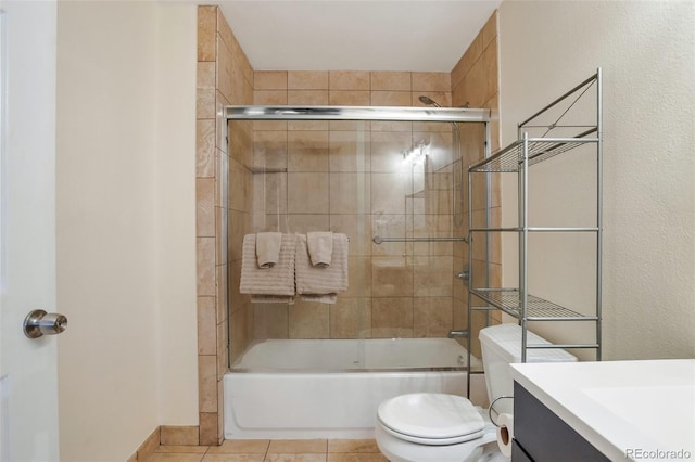 full bathroom with tile patterned floors, vanity, combined bath / shower with glass door, and toilet