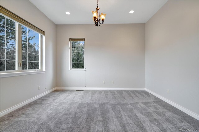 carpeted spare room featuring baseboards, a chandelier, and recessed lighting