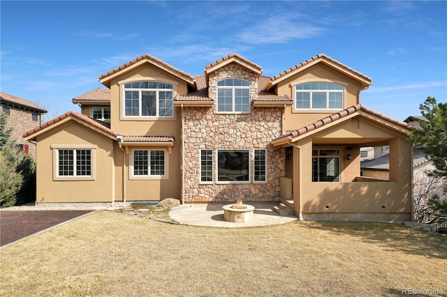 back of property featuring a fire pit, stone siding, a patio area, and stucco siding