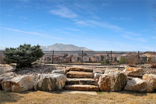 view of yard featuring fence and a mountain view