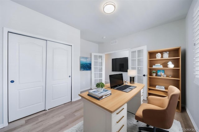 office featuring light wood-style floors, baseboards, and visible vents