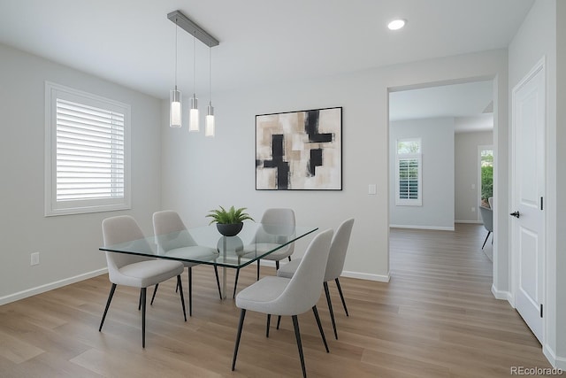 dining space featuring baseboards, recessed lighting, and light wood finished floors