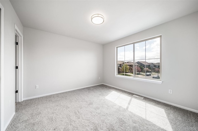 carpeted spare room with baseboards and visible vents