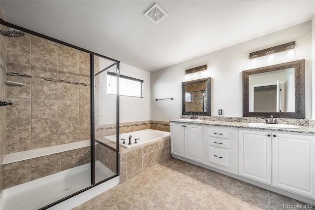 bathroom with visible vents, a sink, a bath, and a stall shower