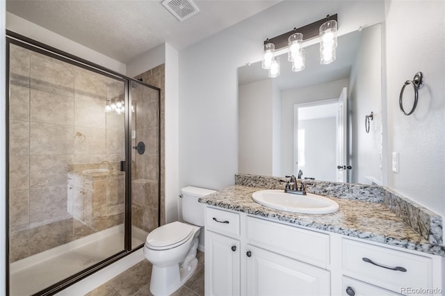 full bathroom featuring tile patterned flooring, vanity, toilet, visible vents, and a stall shower