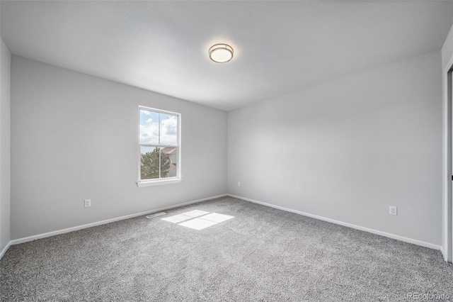 carpeted spare room with baseboards and visible vents