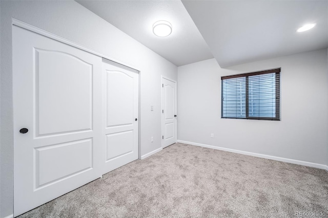unfurnished bedroom with a closet, baseboards, and carpet flooring