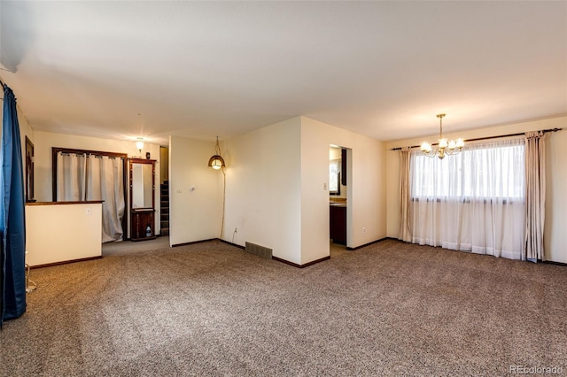carpeted spare room featuring a chandelier and baseboards