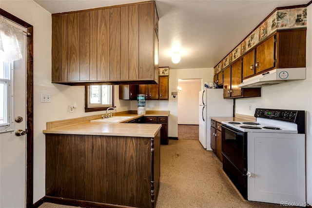 kitchen featuring electric range, a sink, light countertops, a peninsula, and under cabinet range hood
