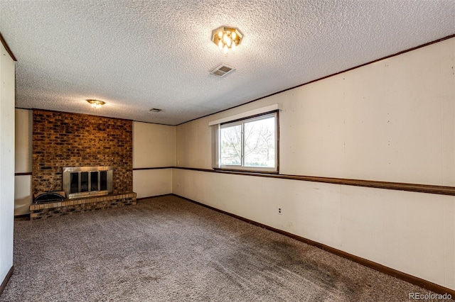 unfurnished living room with a textured ceiling, carpet floors, a brick fireplace, and baseboards