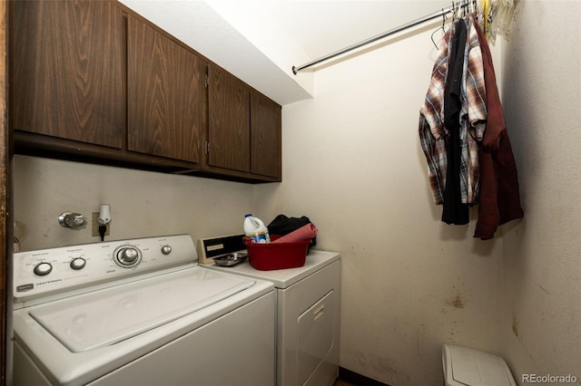 clothes washing area featuring washer and dryer and cabinet space