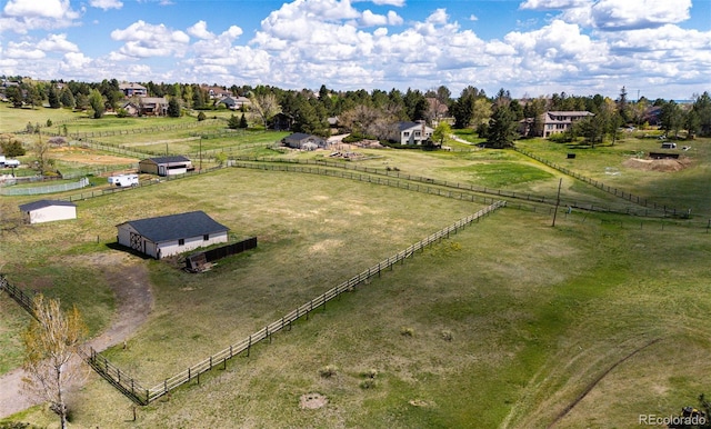 view of rural area with agricultural land and a tree filled landscape