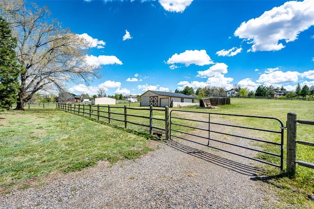 gate featuring a rural view and an outbuilding