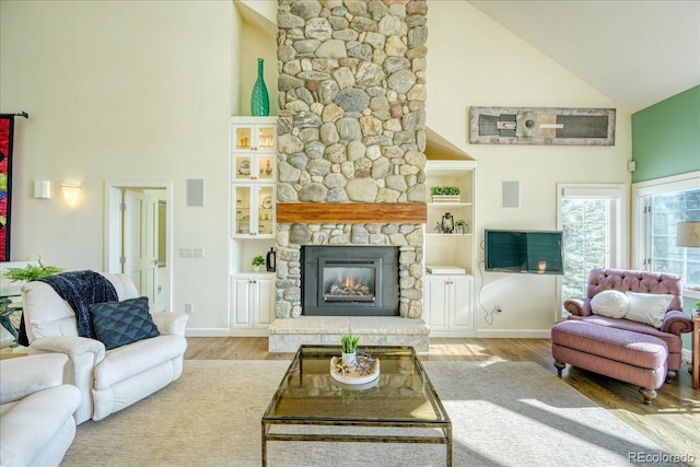 living room with hardwood / wood-style floors, a fireplace, and high vaulted ceiling