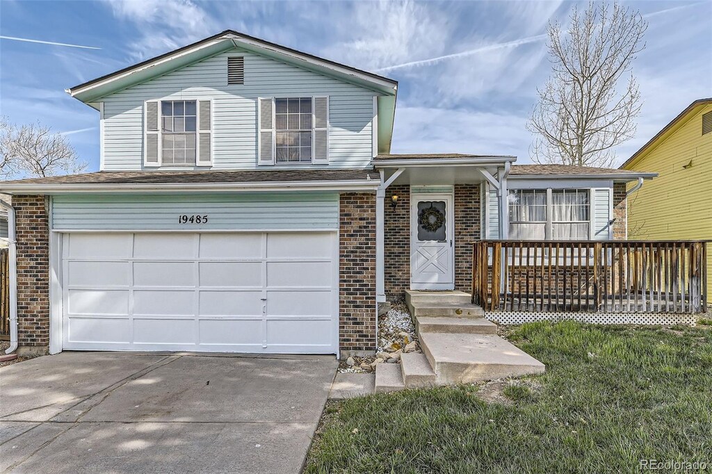 19485 E Purdue Pl, Aurora, CO 80013 - view of front of property with brick siding, an attached garage, and driveway