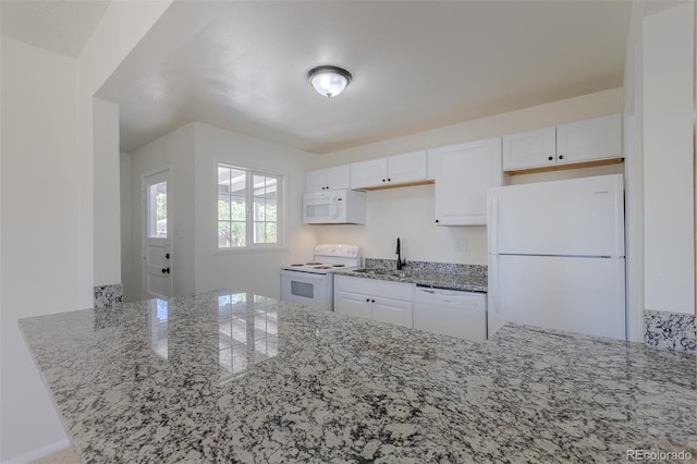 967 Victor St, Aurora, CO 80011 - kitchen featuring white appliances, light stone countertops, white cabinets, a sink, and a peninsula