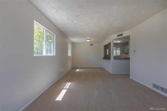 967 Victor St, Aurora, CO 80011 - unfurnished room with baseboards, light carpet, and a textured ceiling