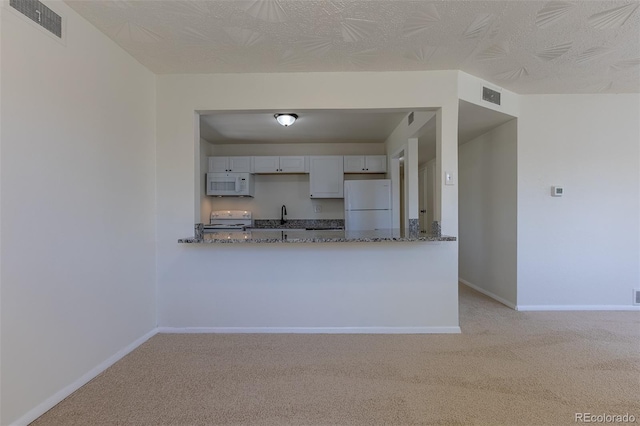 967 Victor St, Aurora, CO 80011 - kitchen featuring white appliances, light colored carpet, dark stone countertops, and baseboards