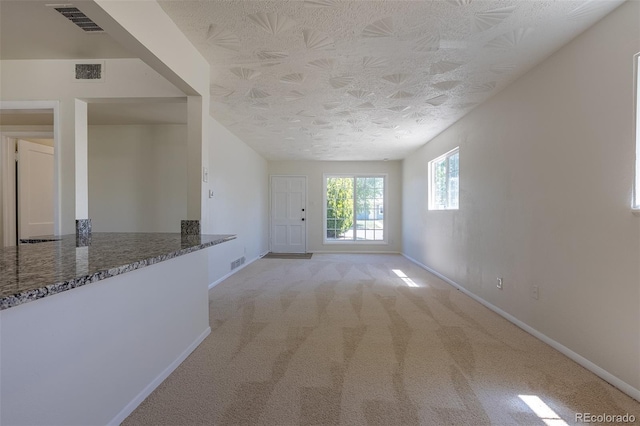 967 Victor St, Aurora, CO 80011 - unfurnished living room with baseboards, a textured ceiling, and light colored carpet