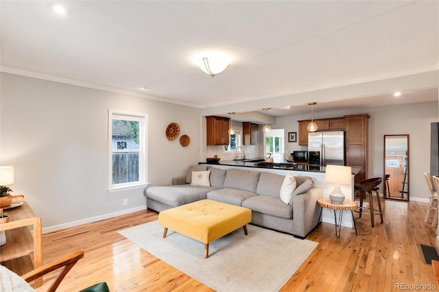 3175 S Pennsylvania St, Englewood, CO 80113 - living room with light wood finished floors, baseboards, crown molding, plenty of natural light, and recessed lighting