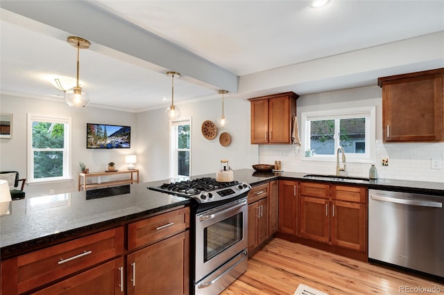 3175 S Pennsylvania St, Englewood, CO 80113 - kitchen with stainless steel appliances, a sink, crown molding, dark stone countertops, and light wood-type flooring