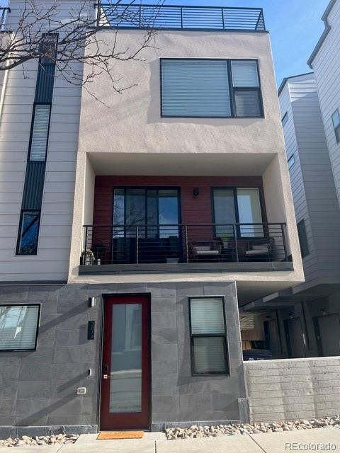 view of front facade with a balcony and stucco siding