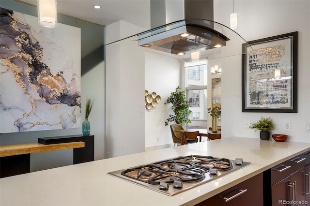 kitchen featuring stainless steel gas stovetop, island exhaust hood, pendant lighting, and dark brown cabinetry