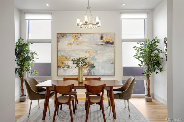 dining area with a notable chandelier, light hardwood / wood-style flooring, and a wealth of natural light