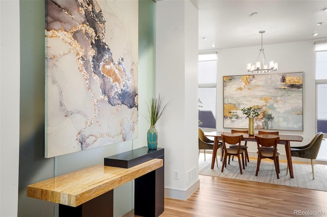 dining area featuring light wood-type flooring and a chandelier