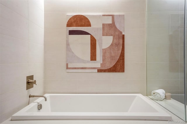 bathroom featuring a tub to relax in and tile walls