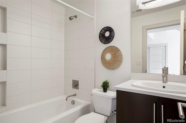 full bathroom featuring tiled shower / bath combo, vanity, and toilet