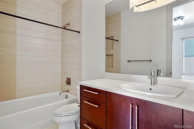 full bathroom featuring vanity, tiled shower / bath combo, and toilet