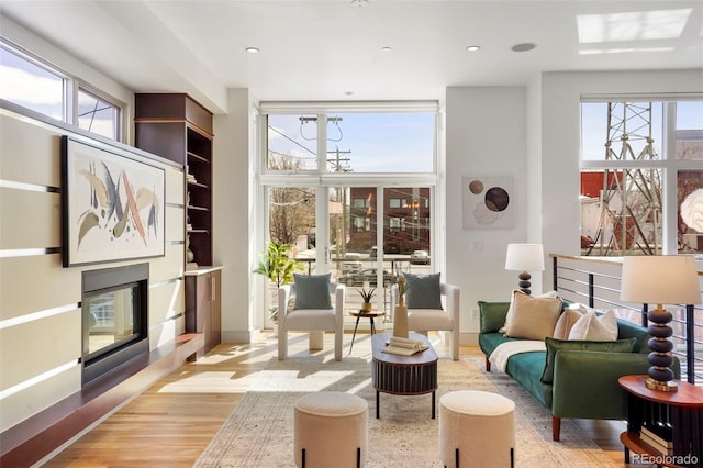 interior space featuring wood finished floors, plenty of natural light, and a glass covered fireplace