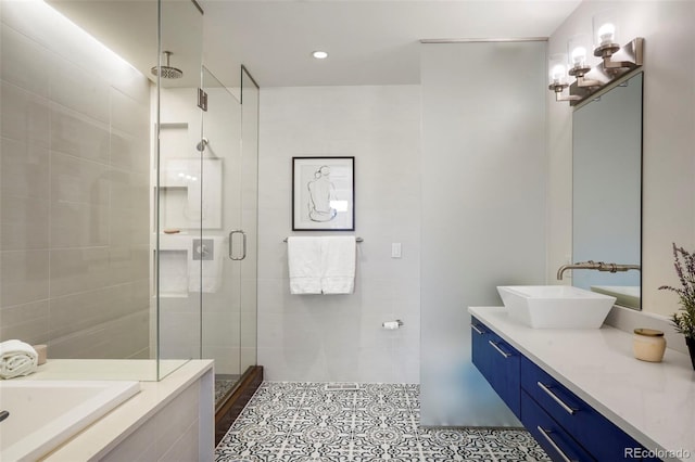 bathroom featuring a washtub, tile patterned flooring, a shower stall, and vanity