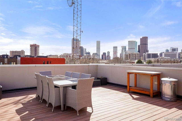 deck with outdoor dining area and a city view