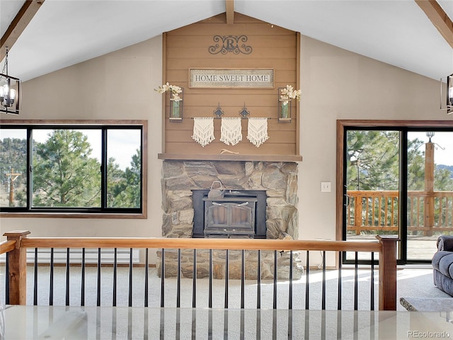 living area with a wealth of natural light, a baseboard heating unit, lofted ceiling, and stairway