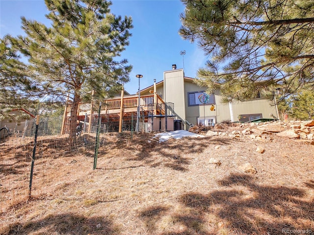 back of property featuring stairway, a chimney, and a wooden deck