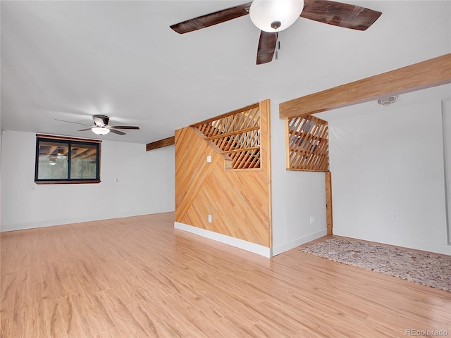 unfurnished living room with ceiling fan, baseboards, and wood finished floors