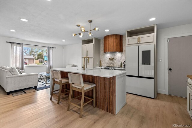 690 S Newark Ct, Aurora, CO 80012 - kitchen with a sink, white fridge, light wood-style floors, and backsplash