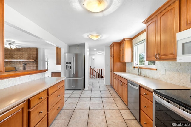 12940 W 75th Ave, Arvada, CO 80005 - kitchen featuring appliances with stainless steel finishes, a sink, tasteful backsplash, and light countertops