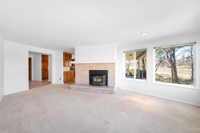 12940 W 75th Ave, Arvada, CO 80005 - unfurnished living room featuring a wood stove, light colored carpet, and baseboards