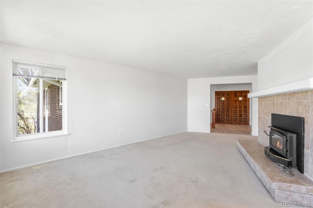 12940 W 75th Ave, Arvada, CO 80005 - unfurnished living room with a wood stove, carpet floors, and baseboards